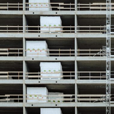 Close-up of a multi-storey building under construction, showcasing steel and concrete structure.