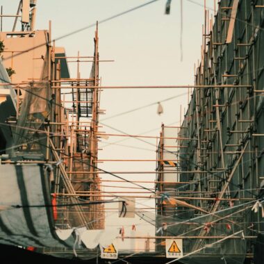 Construction scaffolding in a city with a sunset backdrop creates a striking urban atmosphere.